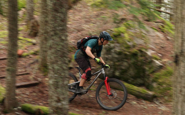 istock Male mountain biker follows trail through forest 1167057561