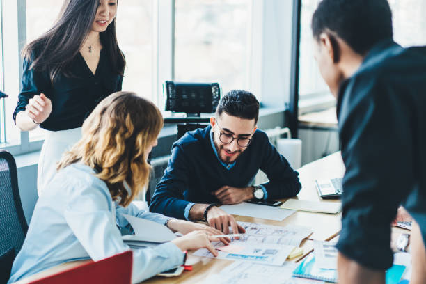 istock Diverse young people discussing strategy and collaborating on building sketch having brainstorming meeting.Multicultural male and female colleagues cooperating on architectural blueprint in office 1167057942