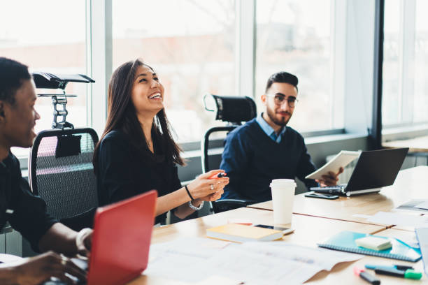 istock Positive diverse team of professionals dressed in formal wear laughing while collaborating on common project during briefing in modern office.Cheerful employees having fun during business meeting 1167058093