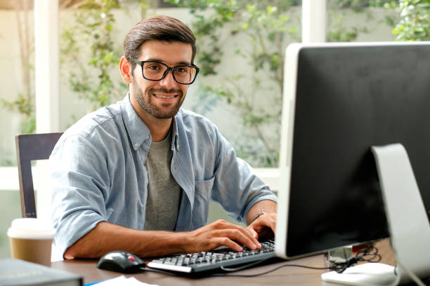 istock Handsome engineer man is typing computer on the table in the office with glass window 1167068589