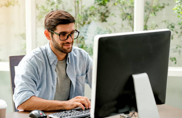 istock Handsome engineer man is typing computer on the table in the office with glass window 1167068628