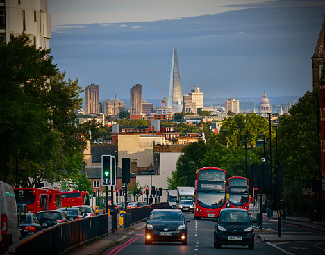 Archway in north London with evening city traffic and the distant skyline of the City  - St Paul's Cathedral and Shard dominate