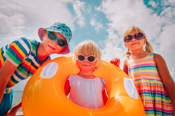 istock happy cute boy and girls play with floaties on beach 1167074994