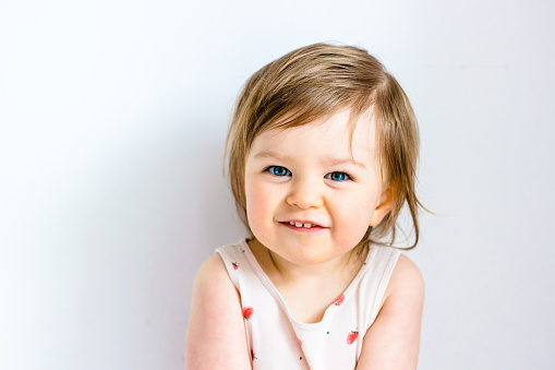 Happy smiling funny toddler child girl on white background