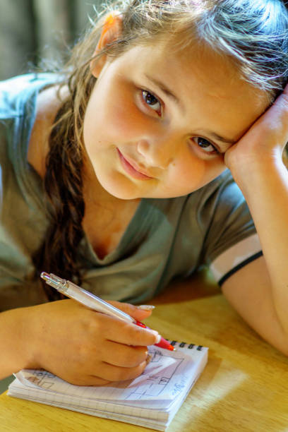 istock Eleven year old girl writing in notepad 1167079545