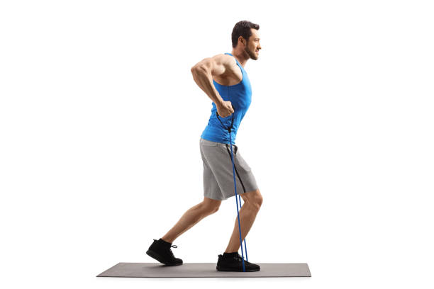 istock Young guy with a resistance band exercising on a mat 1167082953