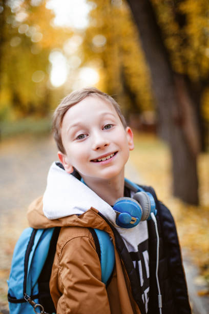 istock Cute caucasian child boy with backpack and ear pots going to school with fun. 1167083384