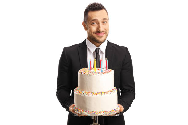 istock Handsome elegant man in a suit holding a cake with candles 1167085702
