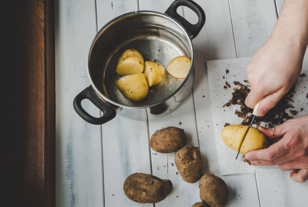 istock Peeling potatoes, view from above on a light background. The concept of preparing dinner. 1167086022