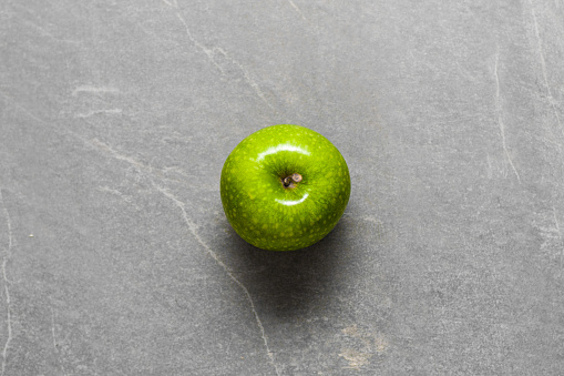 Green juicy Apple on Grey stone