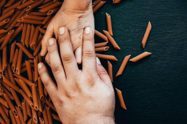 Couple hands over whole grain penne pasta