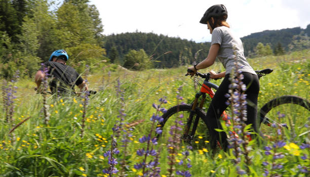 istock Young couple push their mountain bikes up a lush meadow 1167094122