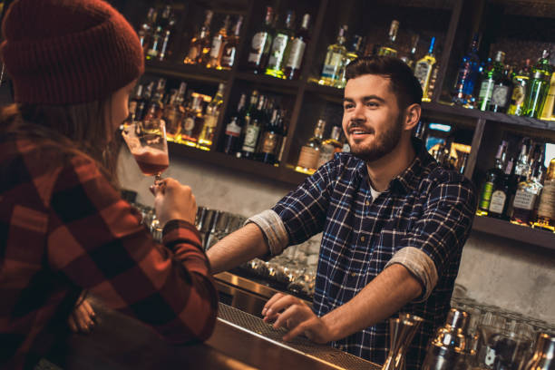istock Young bartender standing at bar counter talking with girl joyful 1167097188
