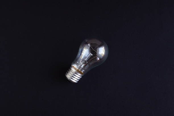 istock transparent ordinary incandescent lamp on a black background top view 1167098507
