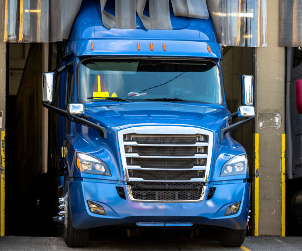 istock Big rig blue semi truck loading commercial cargo in warehouse dock 1167098609