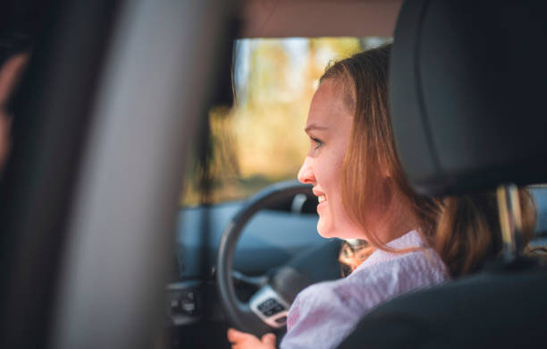 istock Young woman driving car on a sunny day 1167099488