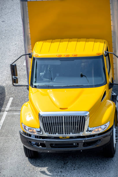 istock Intermediate rig yellow semi Truck with box trailer running on the road 1167100169