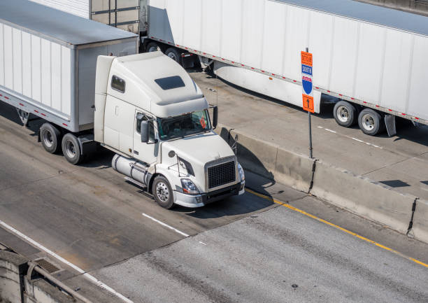 istock Big rigs semi trucks with semi trailers going on the road in in both directions 1167100198
