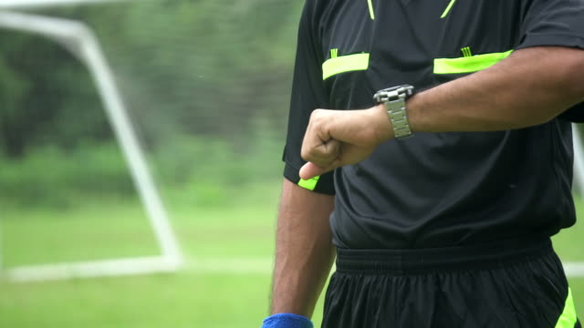 Beginning of the soccer match with referee blowing whistle.