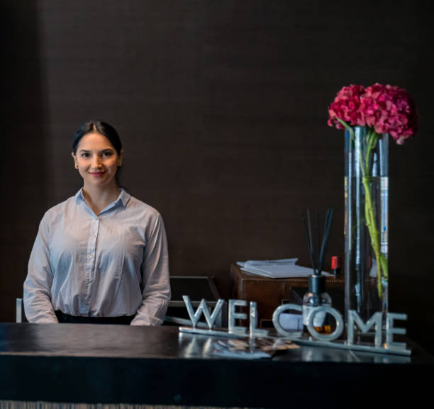 카메라에 미소 카운터 뒤에 서 라틴 아메리카 럭셔리 호텔 접수 - hotel greeting welcome sign service 뉴스 사진 이미지
