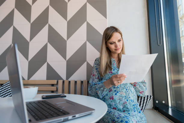 Female freelancer reviews contract while sitting at cafe
