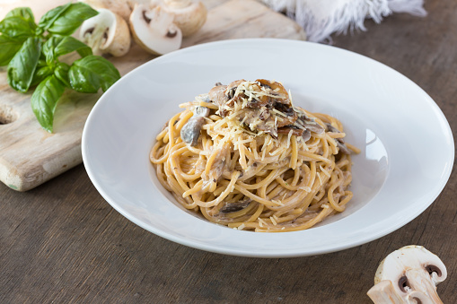 Mushroom Spaghetti Pasta and cream sauce on table, top view. Homemade italian pasta with champignon mushroom.