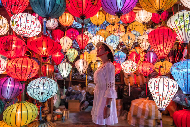 reisefrau wählt laternen in hoi an, vietnam - chinesisches neujahr fotos stock-fotos und bilder