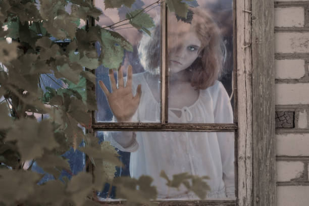 istock girl ghost in the old window 1167121019