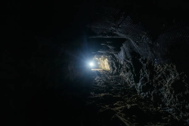 istock Dark dirty abandoned uranium mine with rusty remnants of railway 1167123633