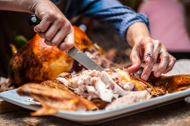 a shot of grease slick hands carving a Thanksgiving turkey