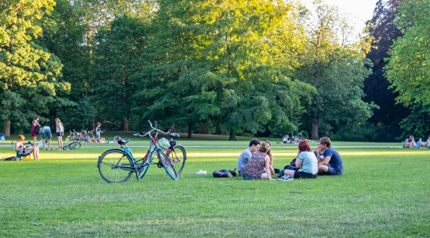 Rotterdam, Netherlands. June 29, 2019. People resting on the grass in a summer afternoon, city park background