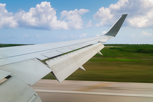 An airplane window view of wing and flaps during landing.