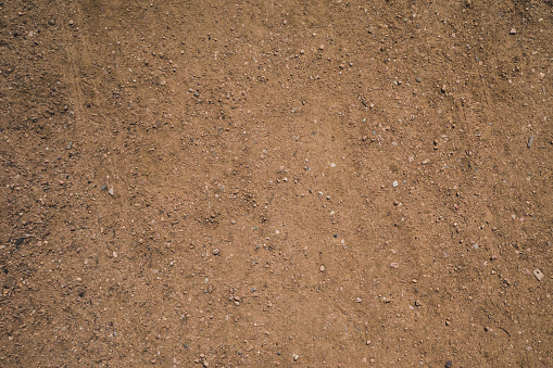 Background texture of dirt road surface with gravels