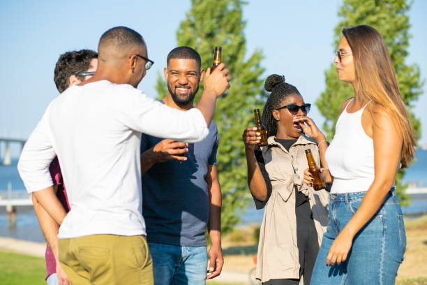 istock Cheerful good friends laughing while drinking beer in park. 1167144159