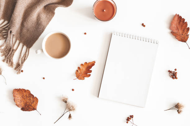 istock Autumn composition. Cup of coffee, plaid, notepad, autumn leaves on white background. Flat lay, top view, copy space 1167145601