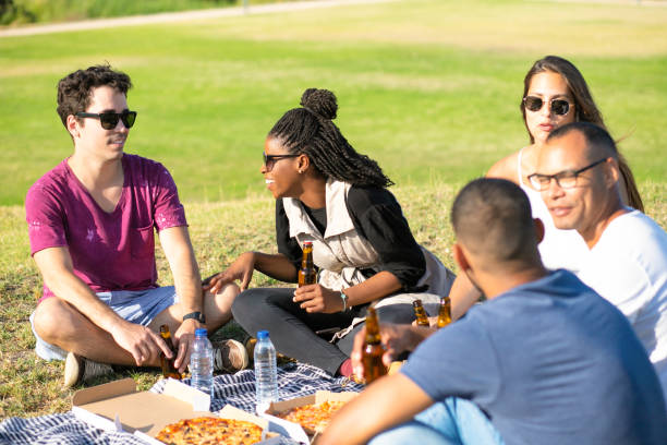 istock Smiling friends with beer bottles during picnic. 1167146430