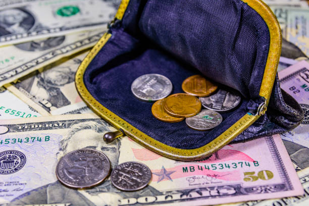 istock Old wallet with american cent coins over the dollar banknotes 1167146586