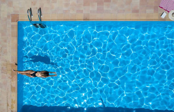 zdjęcia lotnicze młodej kobiety w kostiumie kąpielowym w basenie - resort swimming pool swimming swimming pool women zdjęcia i obrazy z banku zdjęć