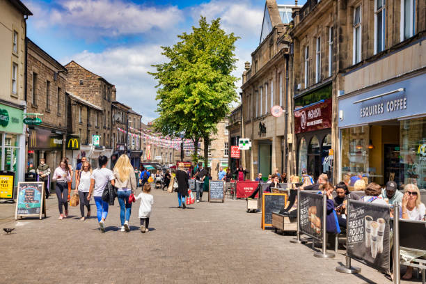 Lancaster, UK, Cheapside, the Main Shopping Street, and People 12 July 2019: Lancaster, UK - A busy day in Cheapside, the main shopping street of the historic town, on a bright sunny day, with people shopping and sitting outside cafes drinking coffee. lancaster lancashire stock pictures, royalty-free photos & images