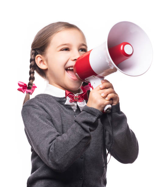 白い背景に孤立したメガホンを通して叫ぶ子供の女子学生。学校の概念に戻る。 - marketing megaphone child using voice ストックフォトと画像