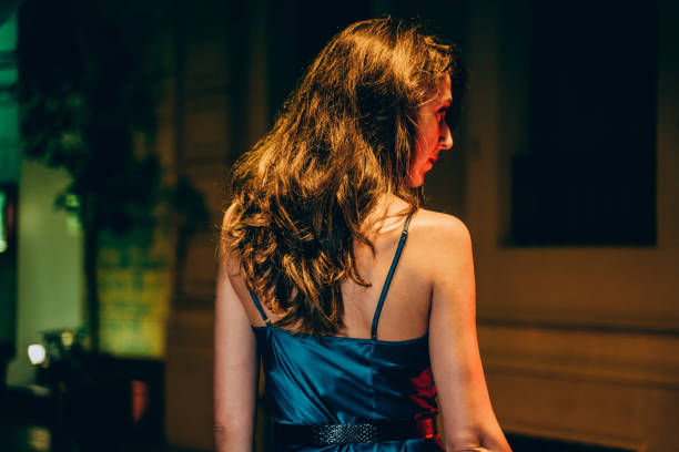 Beautiful woman wearing a blue silk dress at night stock photo