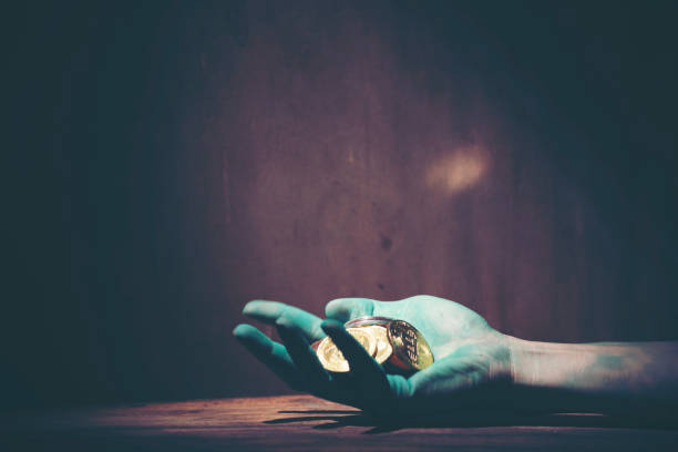 istock Cropped Painted Hand Holding Coins On Table In Dark 1167165299