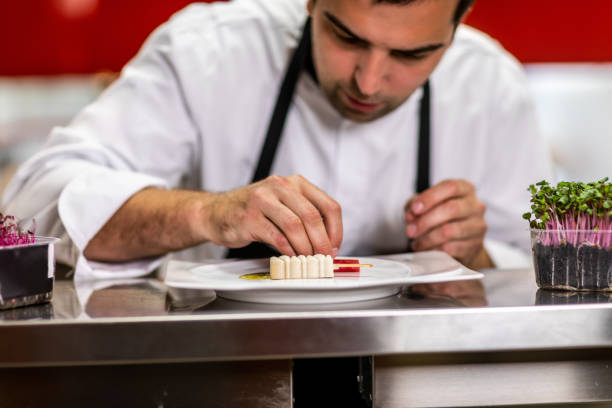 istock Chef decorating a bite-size molecular cuisine dish made to look like ice cream on a stick 1167167447