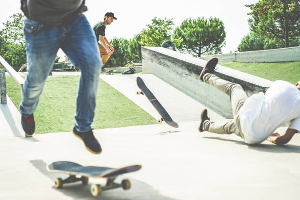 grupo de amigos patinadores realizando truco en el parque pubblic - hombres jóvenes entrenando con skateboards - deporte extremo, concepto de estilo de vida juvenil- céntrese detrás de la cara de hombre - skateboarding skateboard park teenager extreme sports fotografías e imágenes de stock