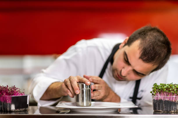 istock Chef decorating a plate of a molecular gastronomy dish using a sifter in a restaurant kitchen 1167167532
