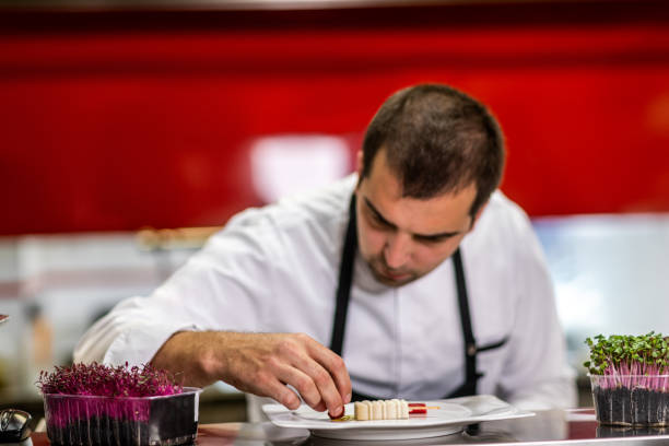 istock Restaurant chef putting decorations on a small, bite-sized molecular gastronomy meal prepared to look like ice cream 1167167633