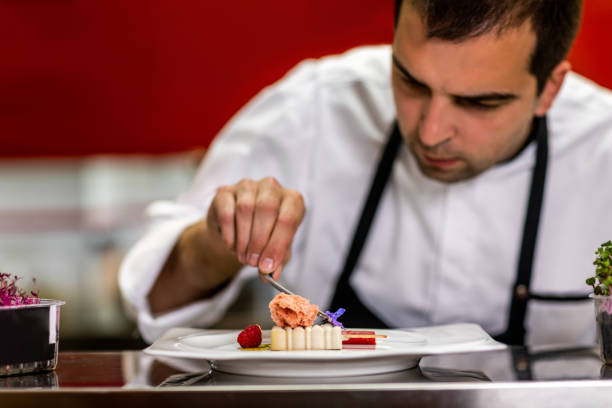 istock Chef putting a blue jasmine flower as a decoration on a molecular cuisine dish made to look like an ice cream 1167167653