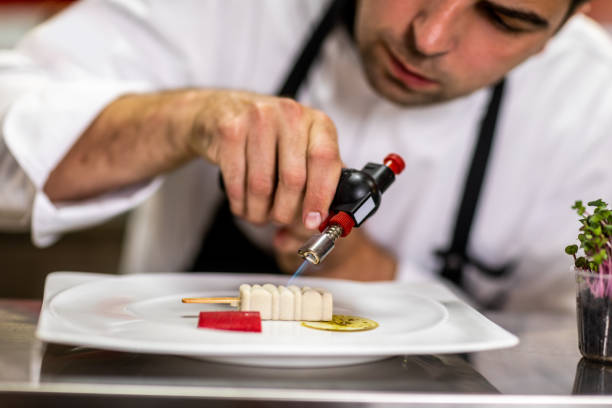 istock Chef using a kitchen blowtorch to caramelize a molecular cuisine meal in a restaurant kitchen 1167168236