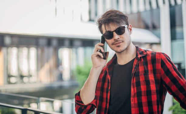 istock Handsome man in plaid shirt talking on phone 1167169530