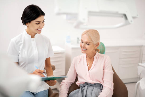 istock Smiling woman sharing her personal information with her dentist. 1167171249